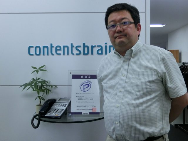 マーケティングプランニングのお客様。プライバシーマーク登録証を手にした様子。