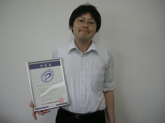 名刺・年賀状印刷システムのお客様。プライバシーマーク登録証を手にした様子。