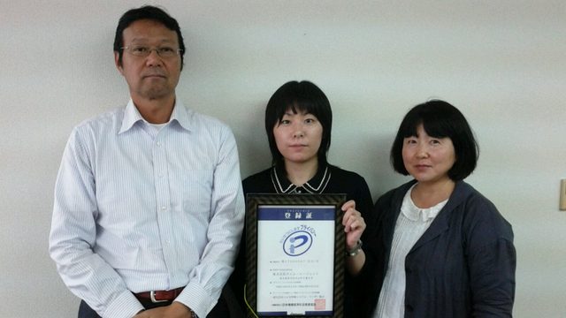 世論・社会・交通調査のお客様。プライバシーマーク登録証を手にした様子。