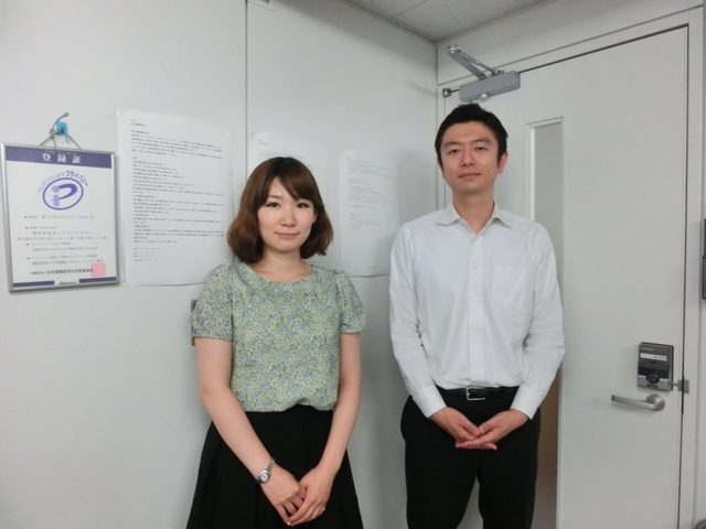プロモーション、広告のお客様。プライバシーマーク登録証を手にした様子。